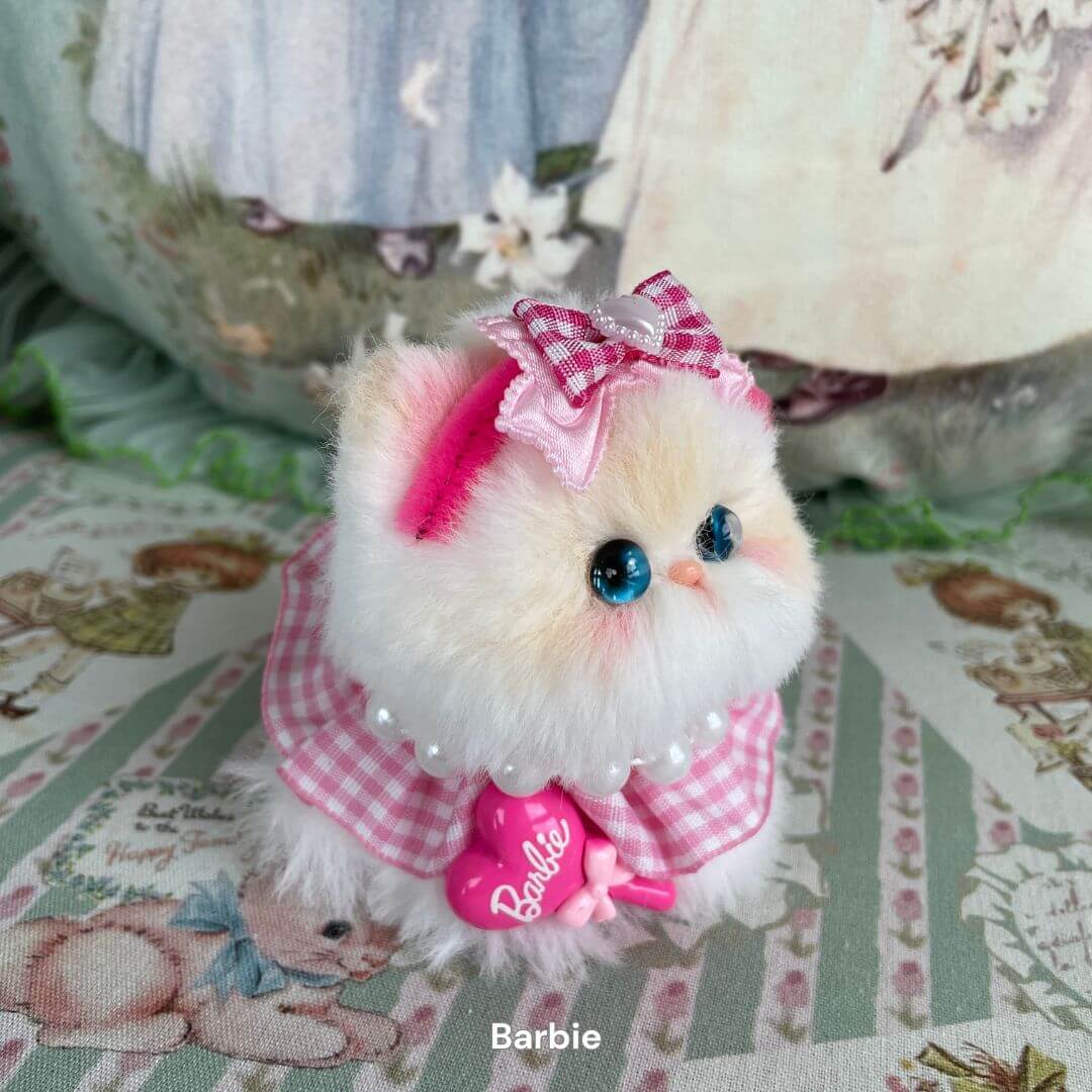 Alt Tag: Handmade plush kitten in pink gingham dress with bow, part of Cosplay Kitten Collection, featuring blue eyes and fluffy fur.
