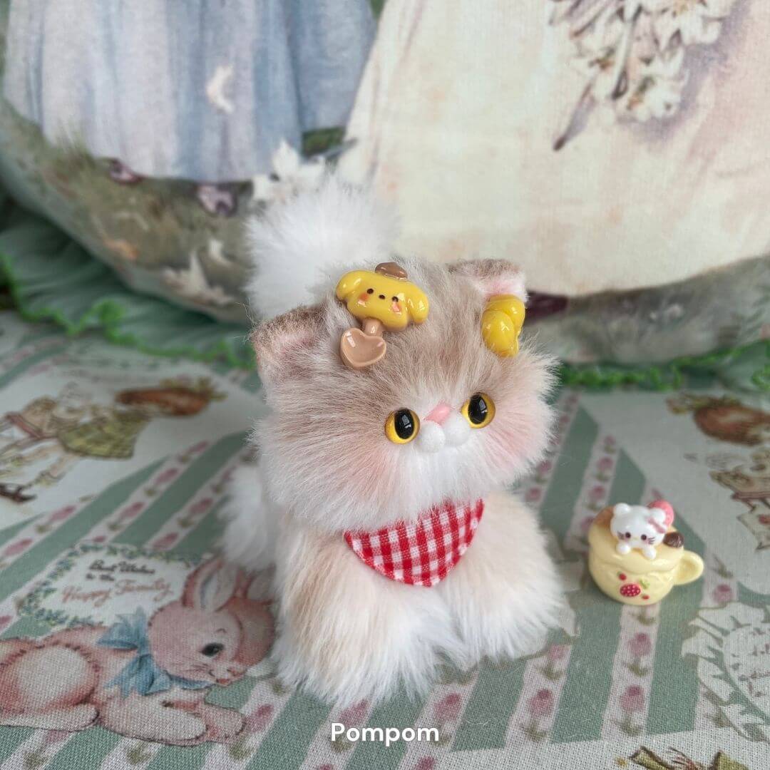 Adorable handmade miniature kitten with faux fur finish, wearing a red-checkered bandana, surrounded by cute accessories.