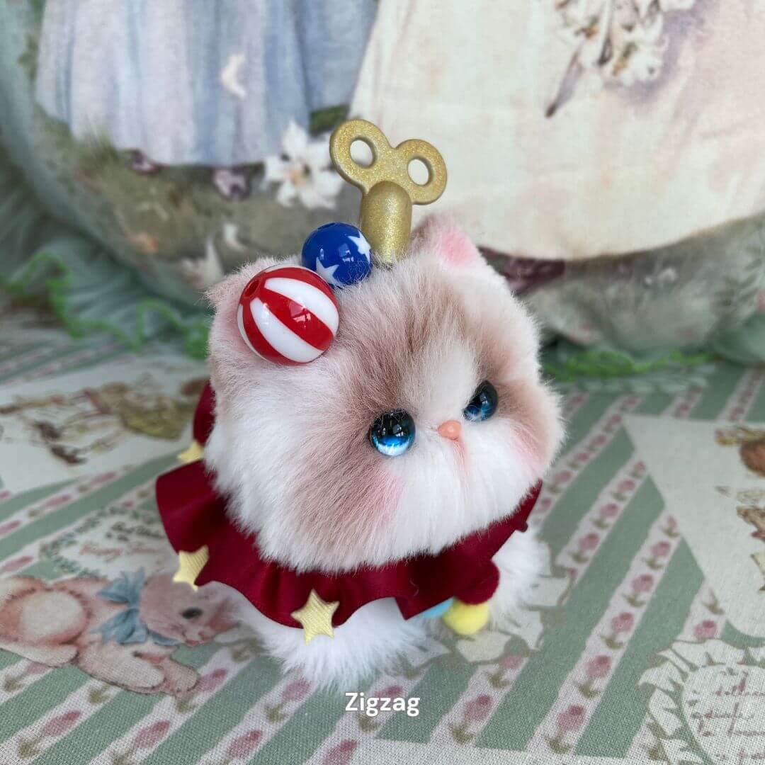 Alt Tag: Handmade cosplay kitten plush toy with red dress, star details, and cute party accessories on a decorative background.