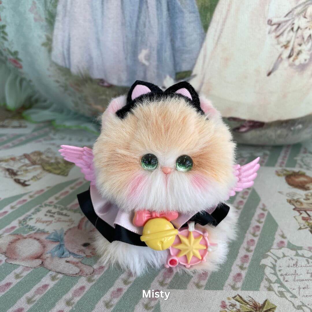 Handmade mini plush kitten with wings, adorned with black bow and whimsical accessories from Cosplay Kitten Collection, named Misty.