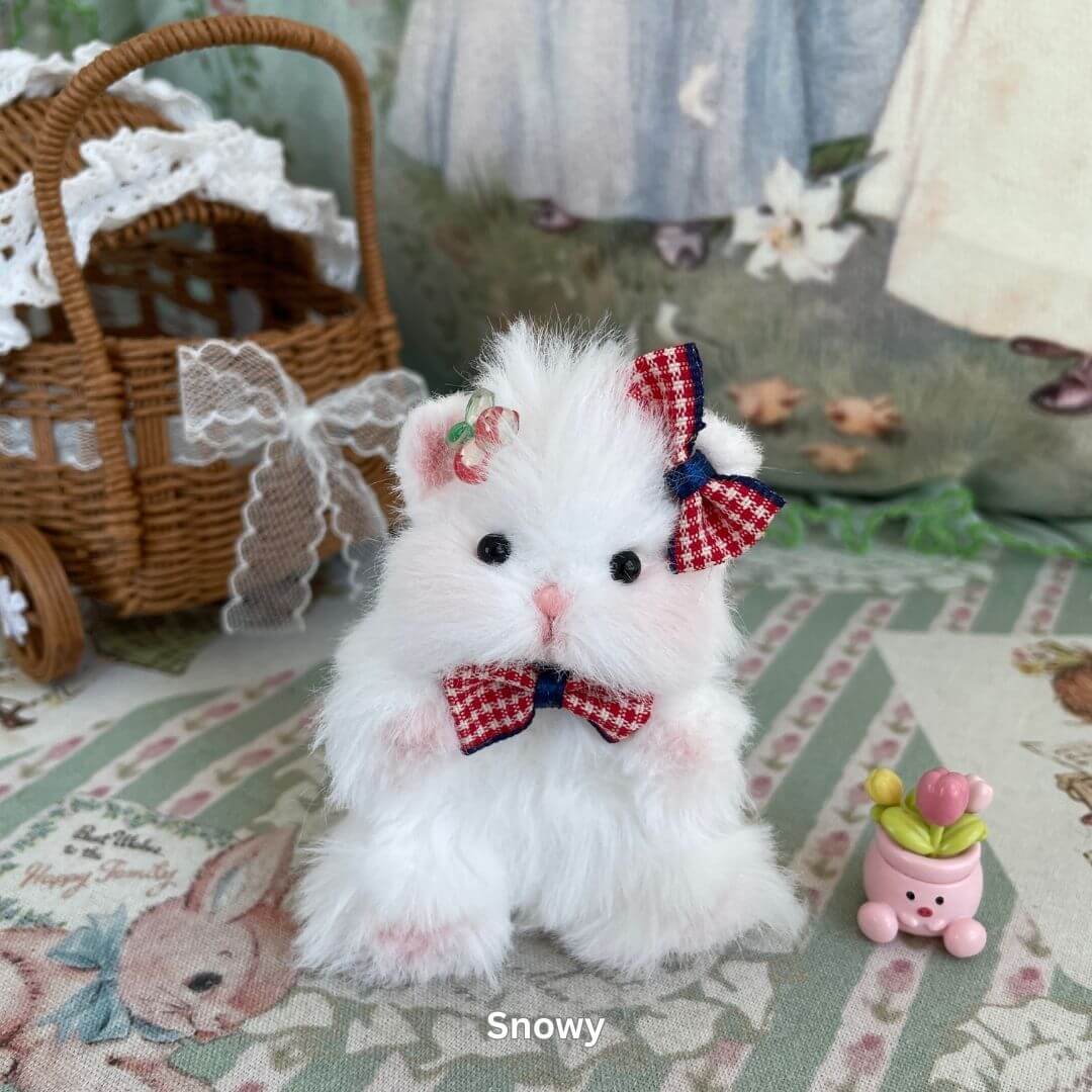 White fluffy hamster toy with bow and flowers, part of Adorable Hamsters Collection, set in a vintage decor with wicker basket.