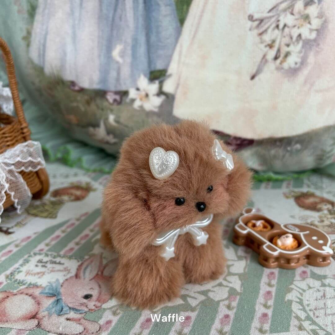 Handmade plush puppy 'Waffle' from Adorable Puppy Collection, with soft brown faux fur and heart accessories, surrounded by cute decor.