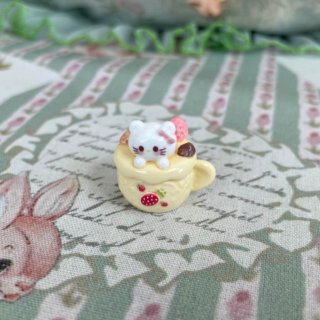 Handmade plush kitty in a dessert cup from Cuppa Kitties collection, featuring a cute strawberry cream design. Collectible toy.