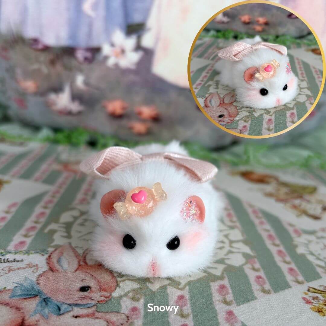 Lying Hamsters Figurines featuring a fluffy white hamster with a pink bow and cupcake accessory, posed adorably on floral background.