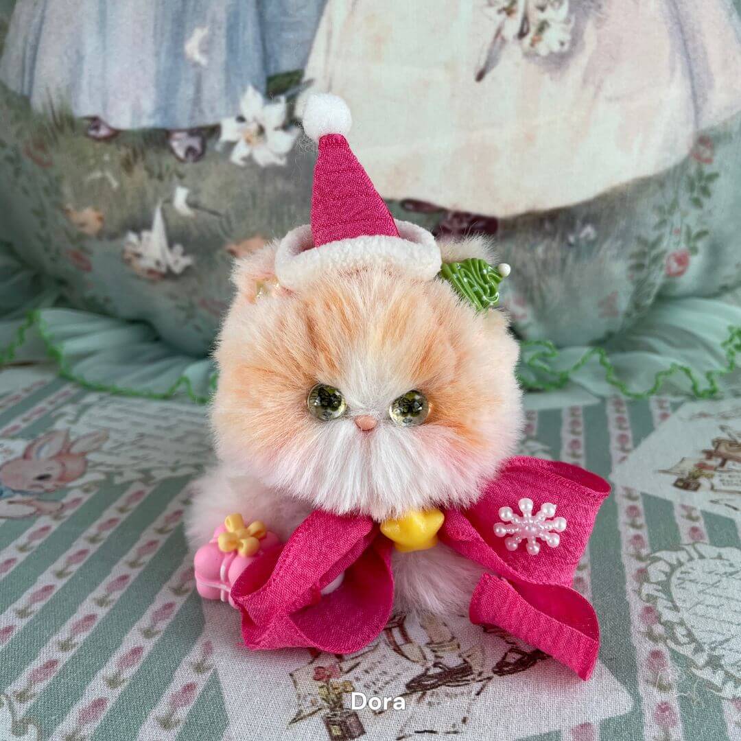 Handmade plush kitten in Fairy Paws Collection with pink Santa hat and bow, ideal for holiday decoration.