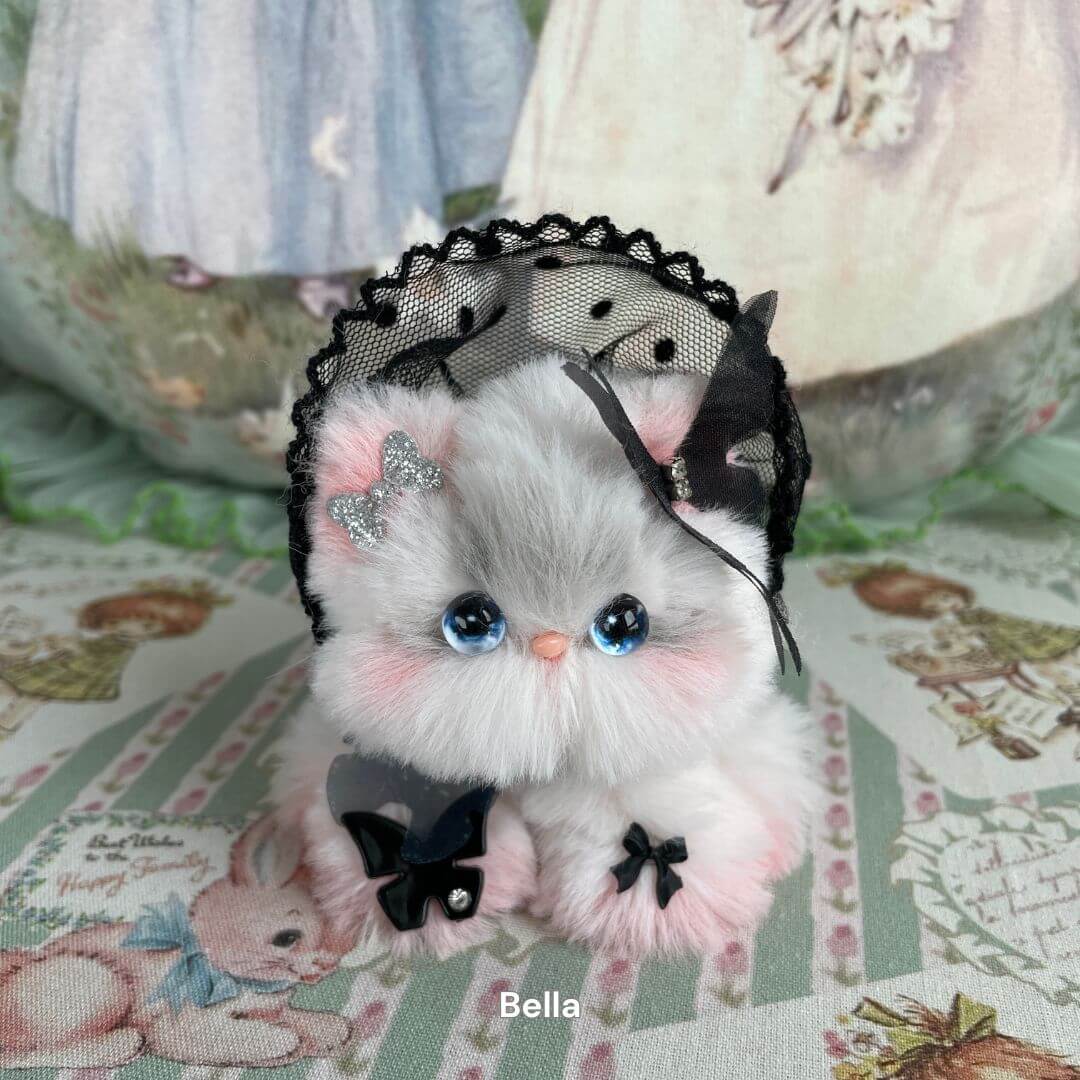 Handmade plush kitten from Fairy Paws Collection with blue eyes, faux fur, and lace headpiece, set in a whimsical setting.