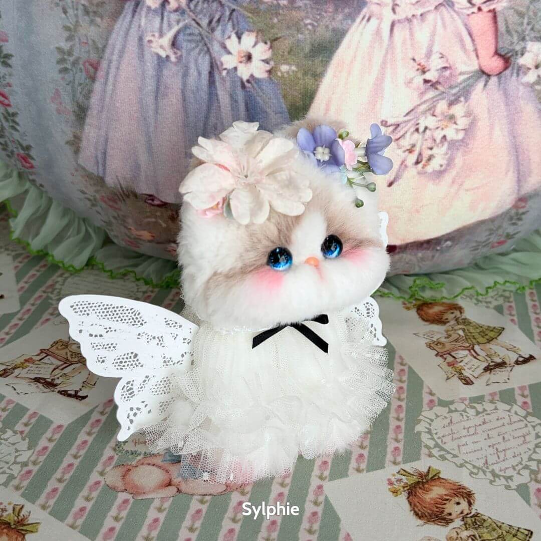 Enchanting fluffy kitten figurine in white dress with wings, adorned with flowers, from the Enchanted Big Paws Collection.