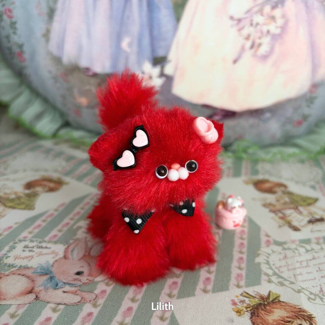 Handmade kitten from the Glossy Meowgic Collection, fluffy red kawaii cat figurine with heart accessories and playful pose.