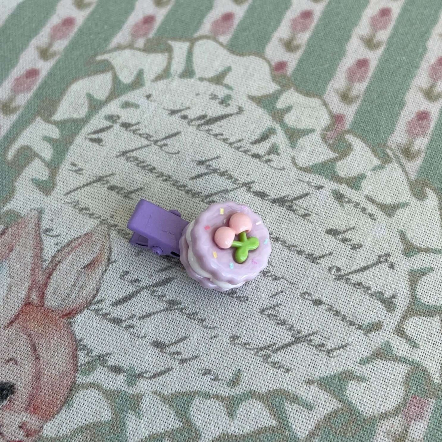 Purple handmade mini clip shaped like a cake, perfect accessory for decorating plush toy kittens and puppies or personalizing bags and clothes.