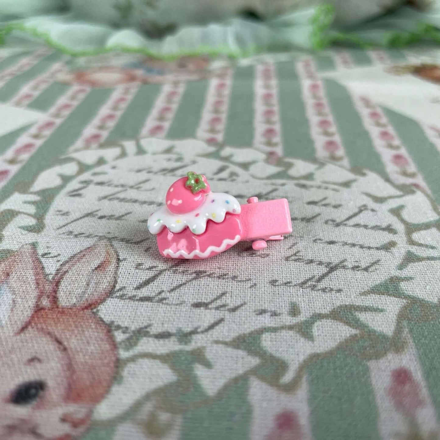 Handmade mini clip with a pink cake design, perfect for accessorizing clothes or plush toys like kittens and puppies.