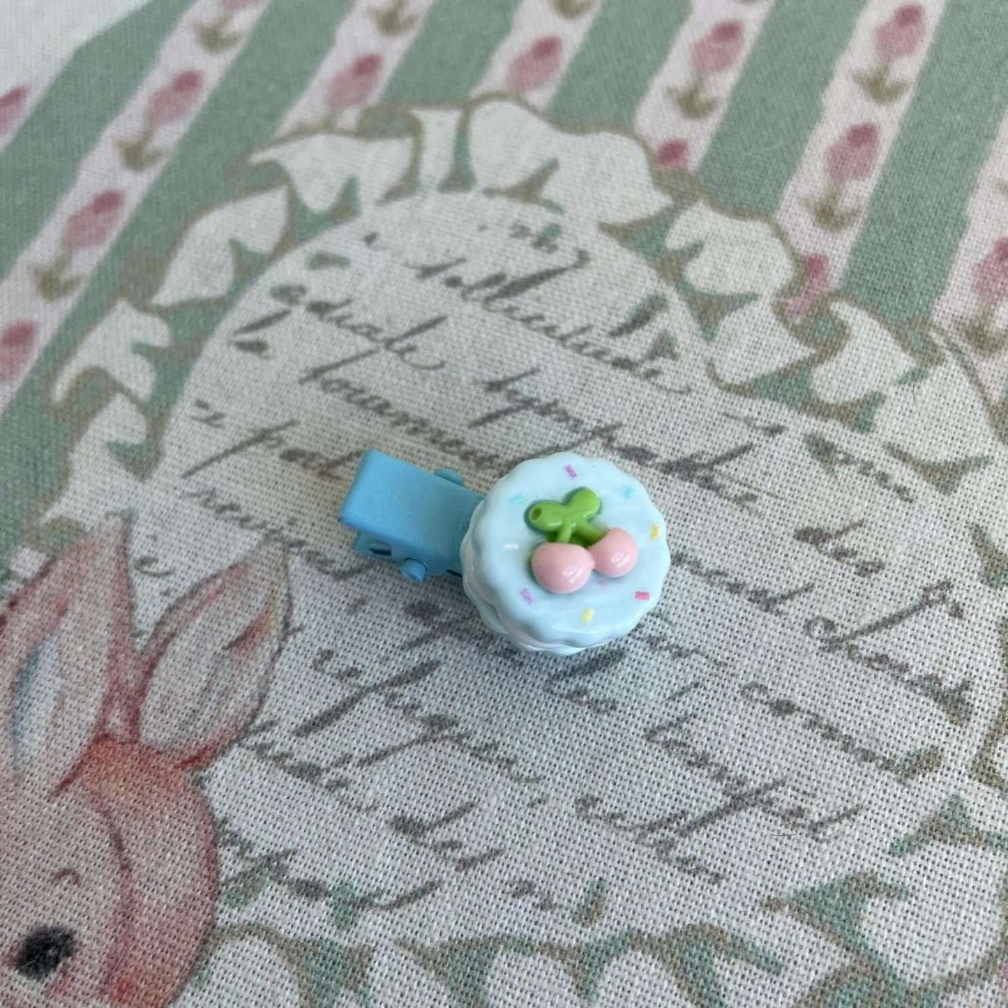 Handmade mini clip featuring a whimsical cake design, perfect for decorating plush toys or as a cute accessory for bags and clothes.