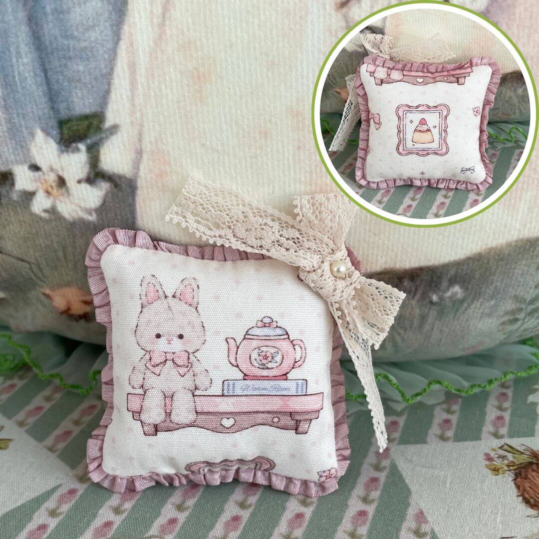 Handmade mini cuddle critter cushion with pink bunny and teapot design, featuring a delicate hand-stitched bow, perfect decoration or doll accessory.