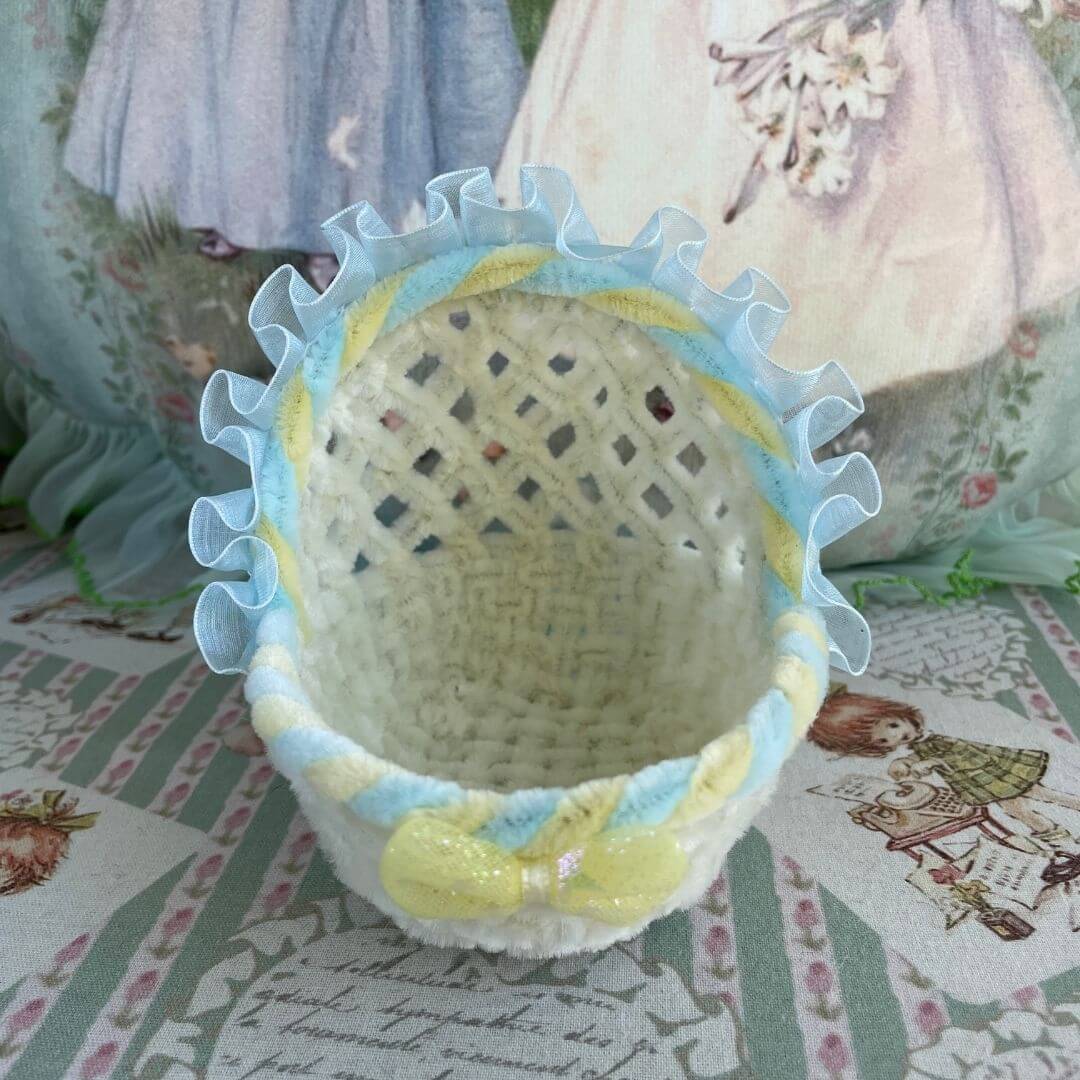 Handmade whimsy cradle with blue ruffles and bow, perfect for dollhouses or pet displays; a charming addition to any miniature scene.