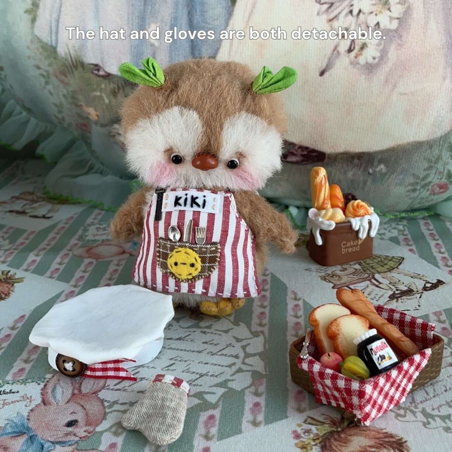 Mini chef plush toy with detachable hat and gloves, wearing a striped apron, surrounded by miniature food props.
