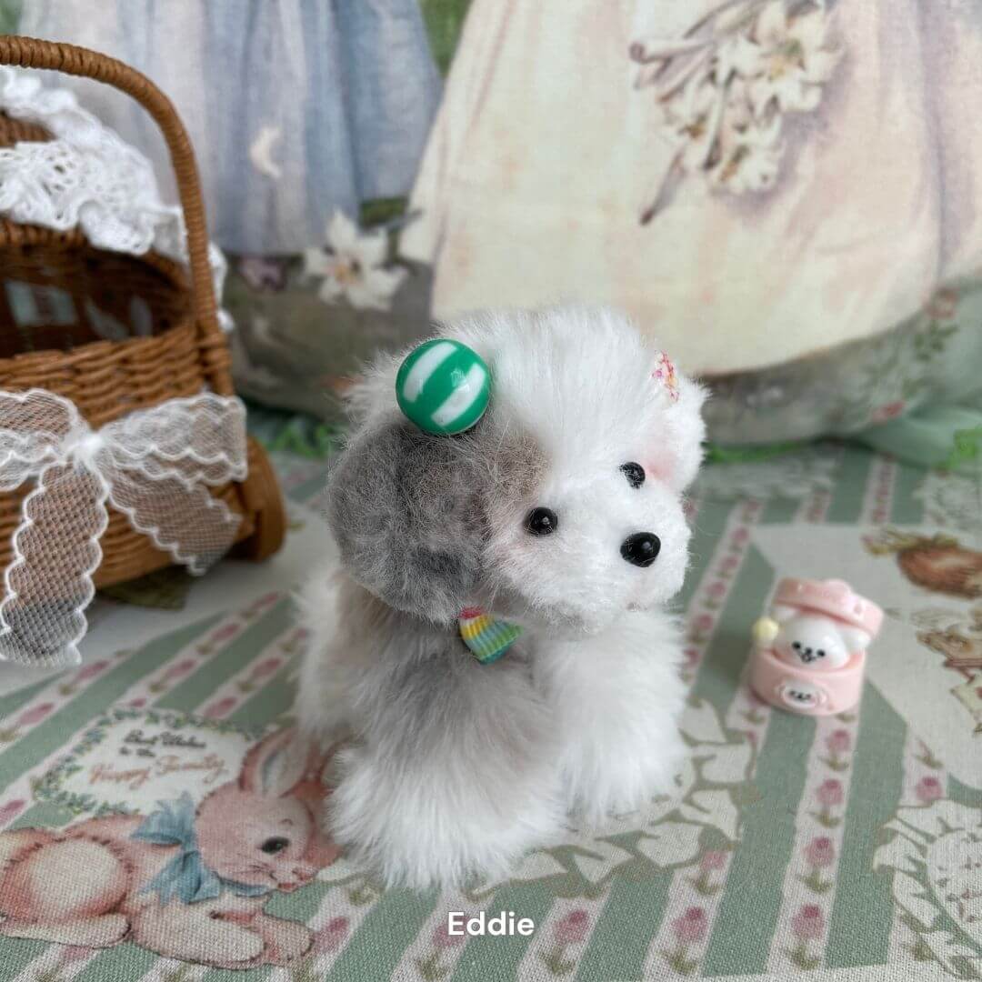 Handmade plush toy puppy from the Adorable Puppy Collection with a green hat, surrounded by cute decorations.