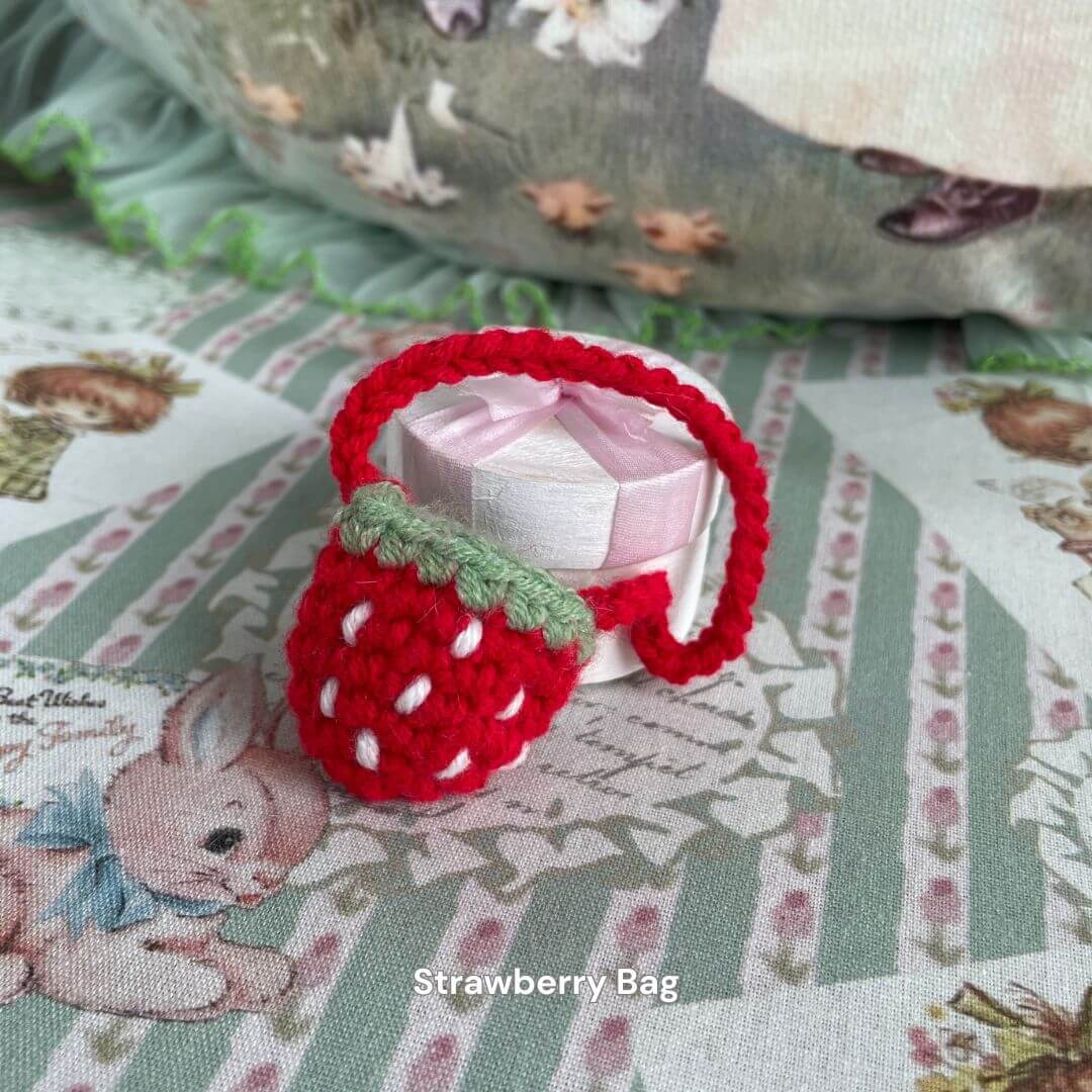 Handmade strawberry mini bag accessory for plush toys, perfect for adding charm to plush kittens or small animal decor.