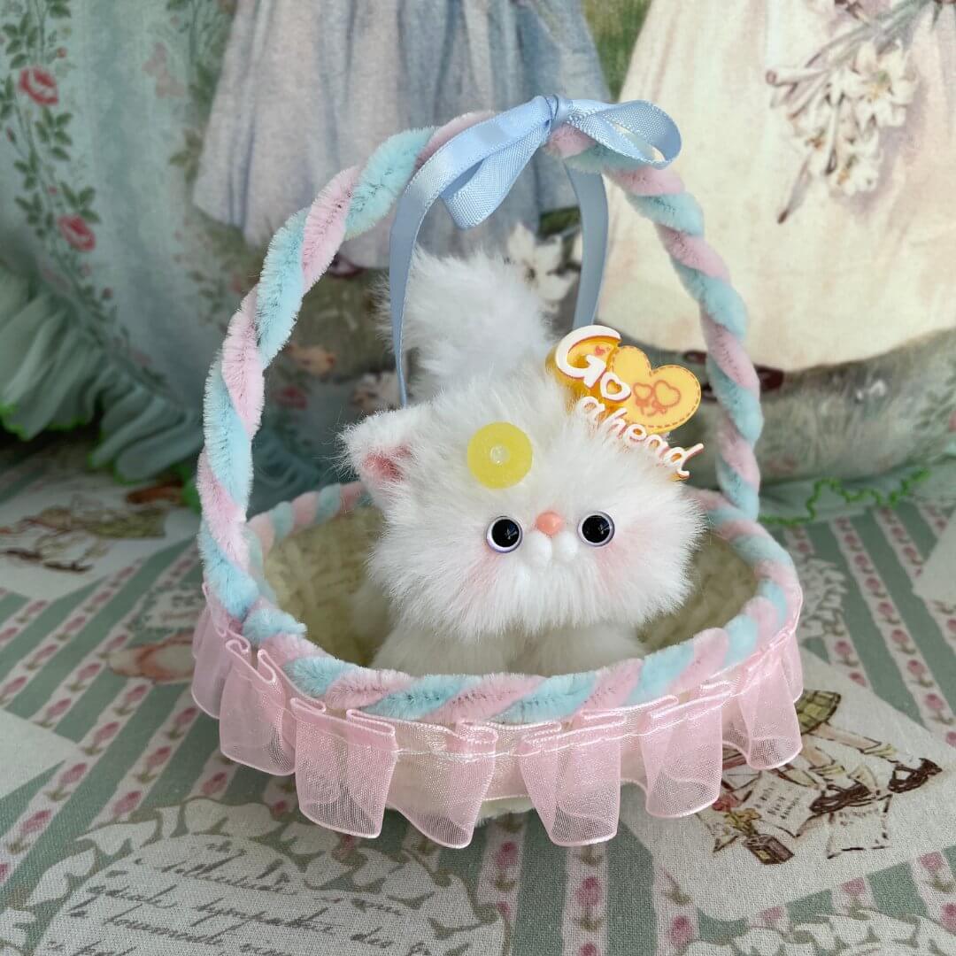 Alt Tag: Handmade whimsy cradle with a plush white kitten toy, featuring pastel decorations, perfect for miniatures or displays.