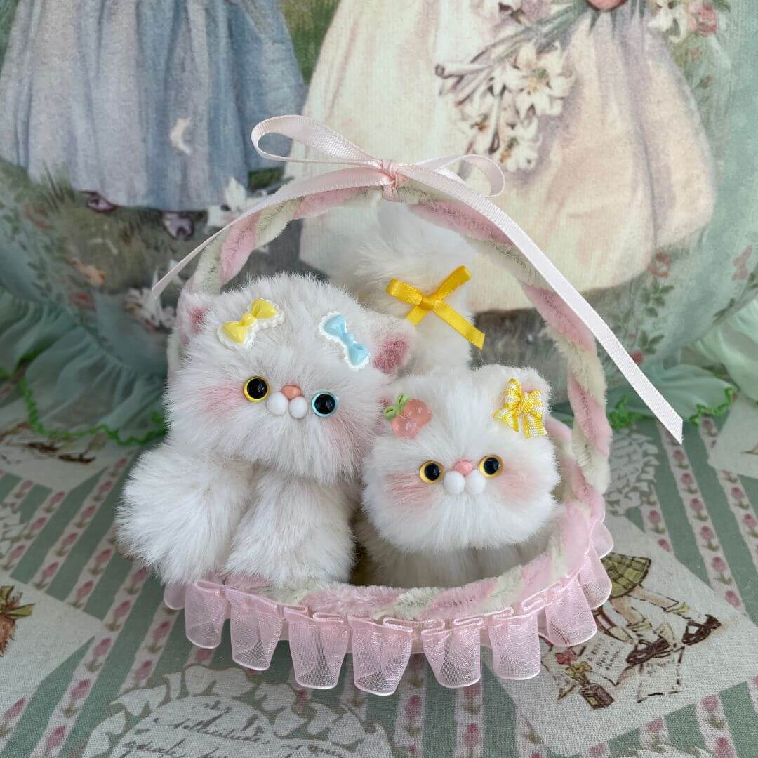 Handmade whimsy cradle with plush kitten toys, decorated with ribbons, perfect for dollhouses or gifts.