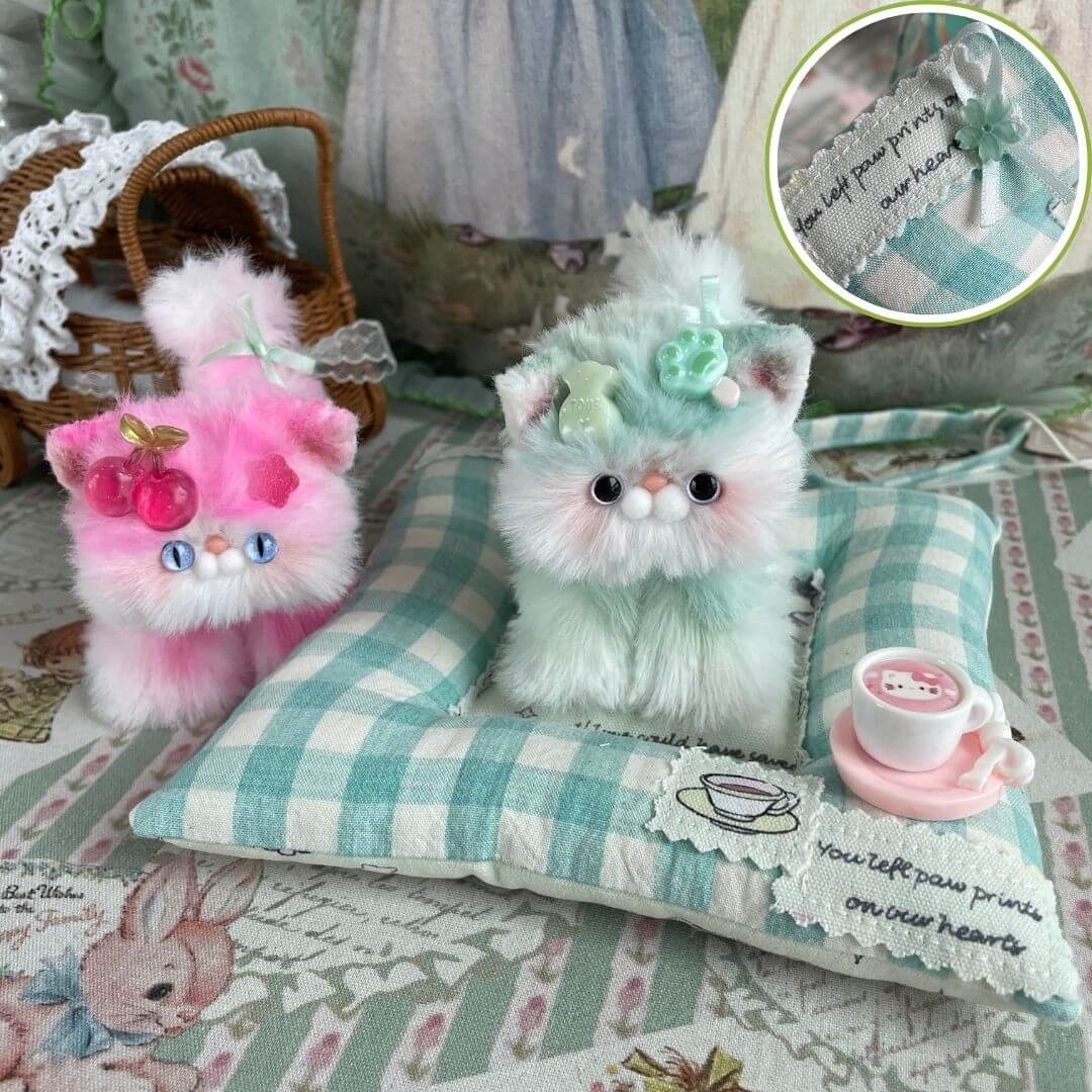 Adorable handmade kitten plush toys with a green-checkered cushion and decorative elements, perfect for kitten lovers.