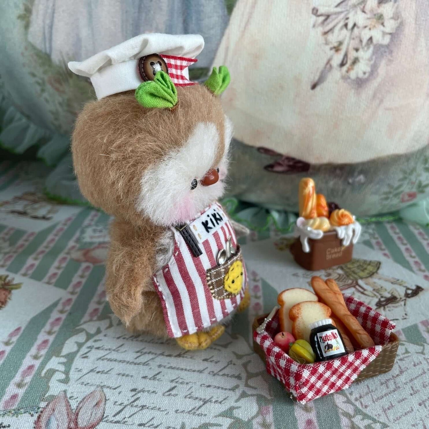 Handmade mini chef penguin with apron and accessories, featuring movable joints, created by René at Kiki's Handmade Studio.