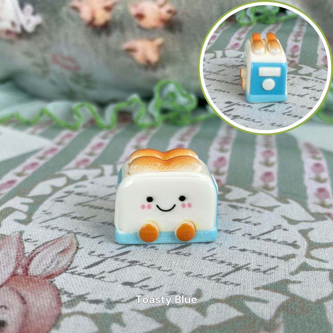 Cute Toasty Blue toaster figurine with adorable smiling face on a patterned tablecloth, surrounded by playful decor elements.