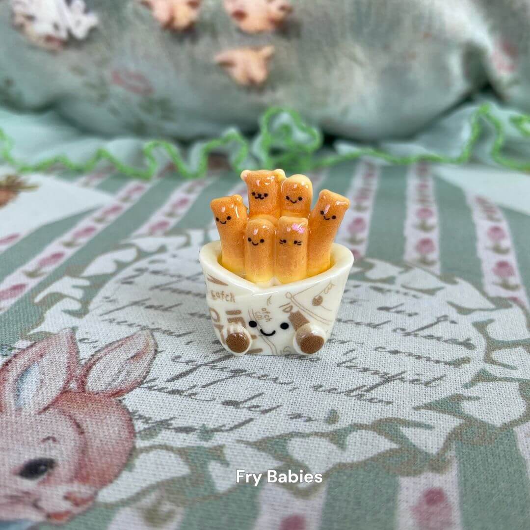 Cute fry plush toys with smiley faces in a decorative basket, perfect for gifting or collecting, part of the Snackie Friends line.