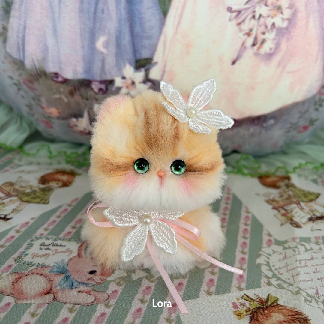 Handmade kitten from the Fairy Paws Collection, fluffy orange and white with pearl accessories and big green eyes.