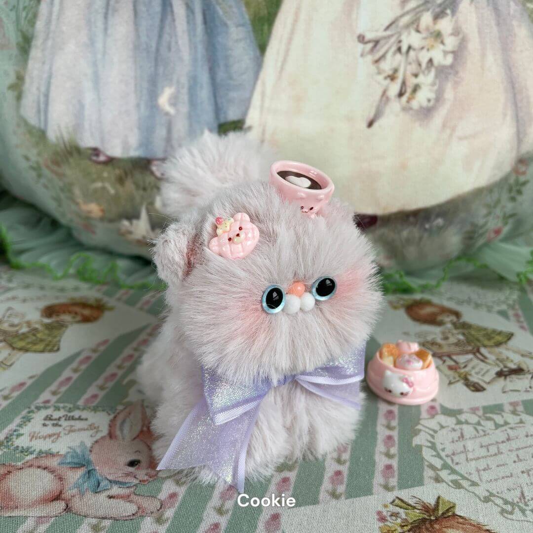 Handmade fluffy kitten plush toy with pastel fur, adorned with pink bows and sweets, from the Fluffy Kitten Collection.