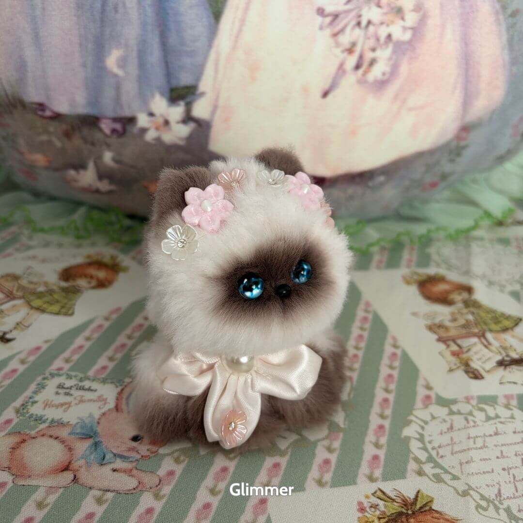 Handmade kitten from the Fairy Paws Collection, featuring fluffy fur, blue eyes, flower crown, and pearl collar, kawaii style.