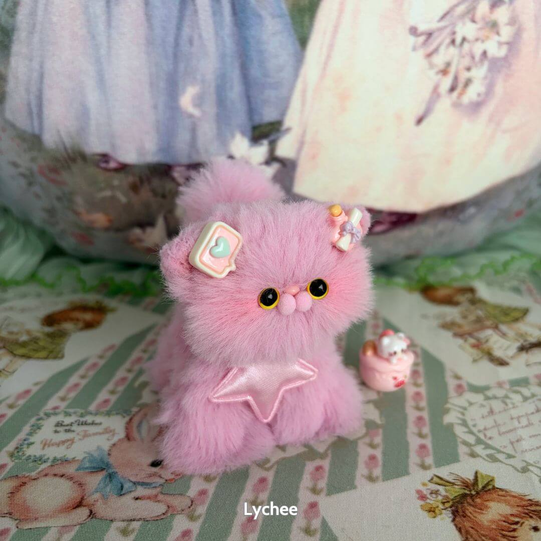 Handmade kitten in fluffy pink fur with cute accessories, part of the Fruity Kitten Collection, resembling lychee fruit.