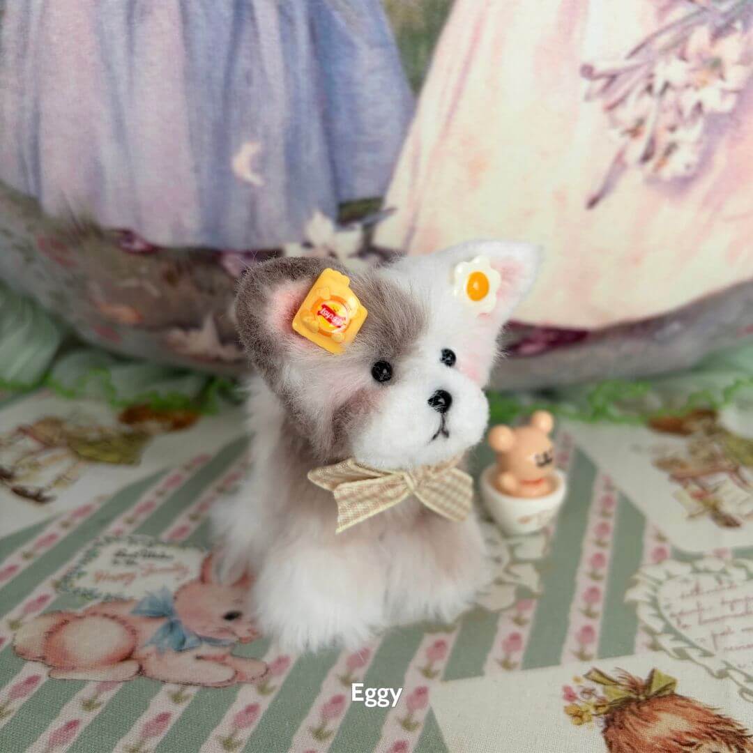 Adorable Puppy Collection featuring a fluffy gray and white puppy with cute accessories and a bow, posed on a decorative surface.