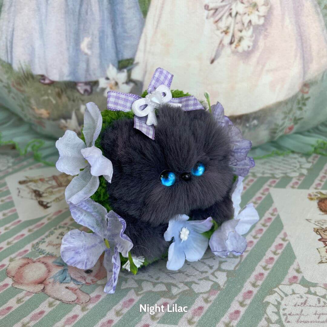 Handmade Kitten Collection: fluffy black kitten with blue eyes in a floral arrangement, wearing a bow, perfect for collectors.
