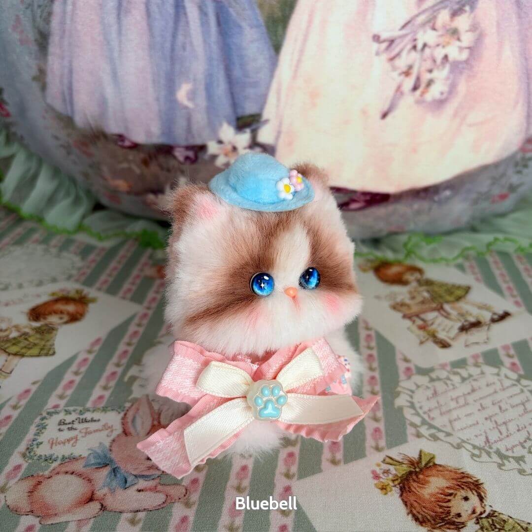 Handmade kitten from the Cosplay Kitten Collection with blue eyes, fluffy fur, pink bow, and a charming blue hat.