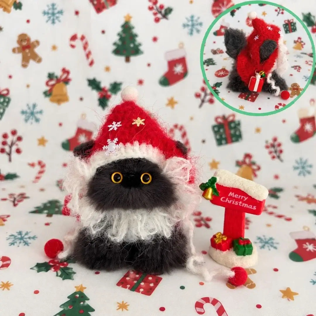 Black kitten dressed as Santa with a red hat and fluffy white beard.