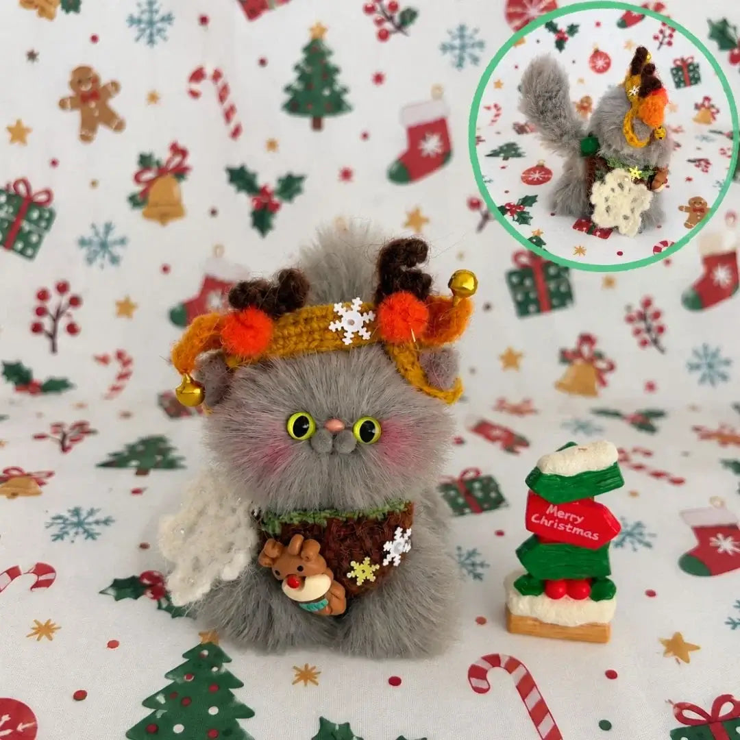 Grey kitten wearing reindeer antlers and a festive scarf.