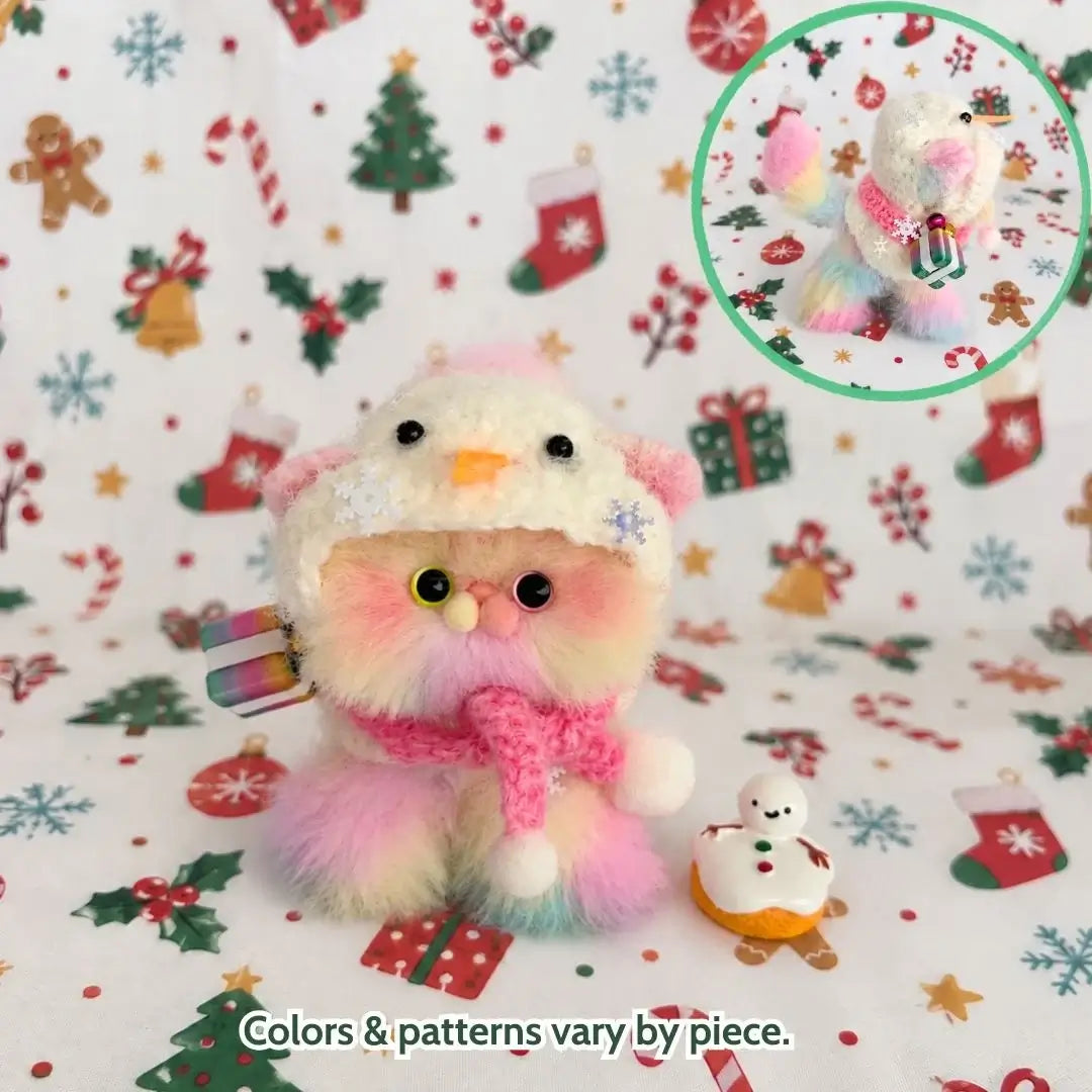 Pastel kitten wearing a snowman hat and a pink scarf.