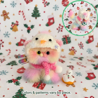 Pastel kitten wearing a snowman hat and a pink scarf.