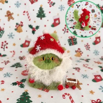 Pistachio-green kitten wearing a red Santa hat and fluffy white trim.
