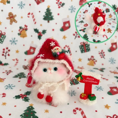 White kitten with blue eyes wearing a red Christmas hood.