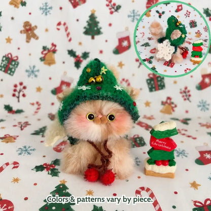 Cream kitten wearing a green Christmas tree hat.