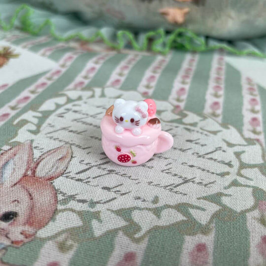 Cute plush white kitten in a pink dessert cup with strawberries, part of the Cuppa Kitties collection of handmade decorative toys.