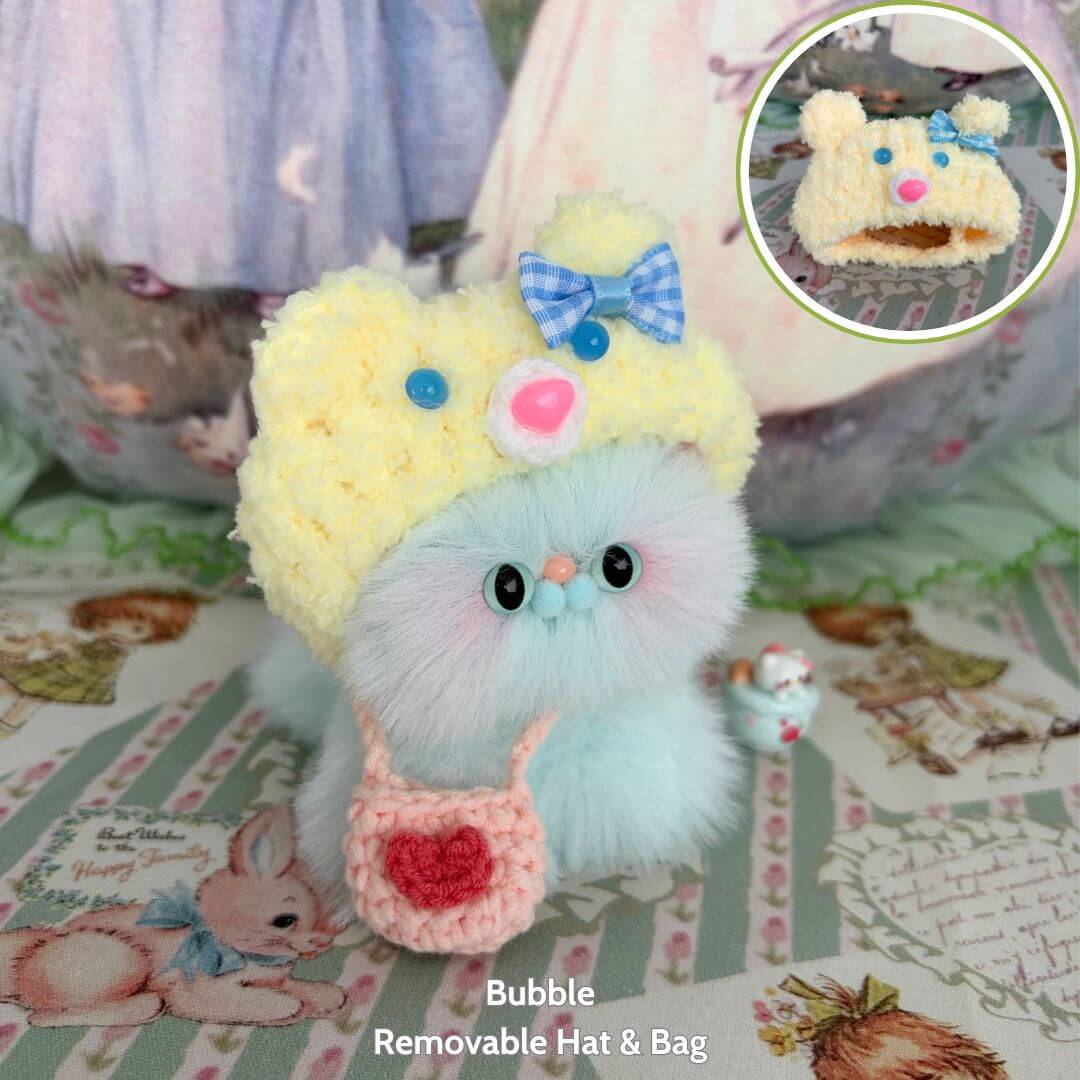 Fluffy Hoodie Kittens: a cute fluffy kitten figurine with a bear hat, pastel blue fur, and a pink bag made with handmade details.