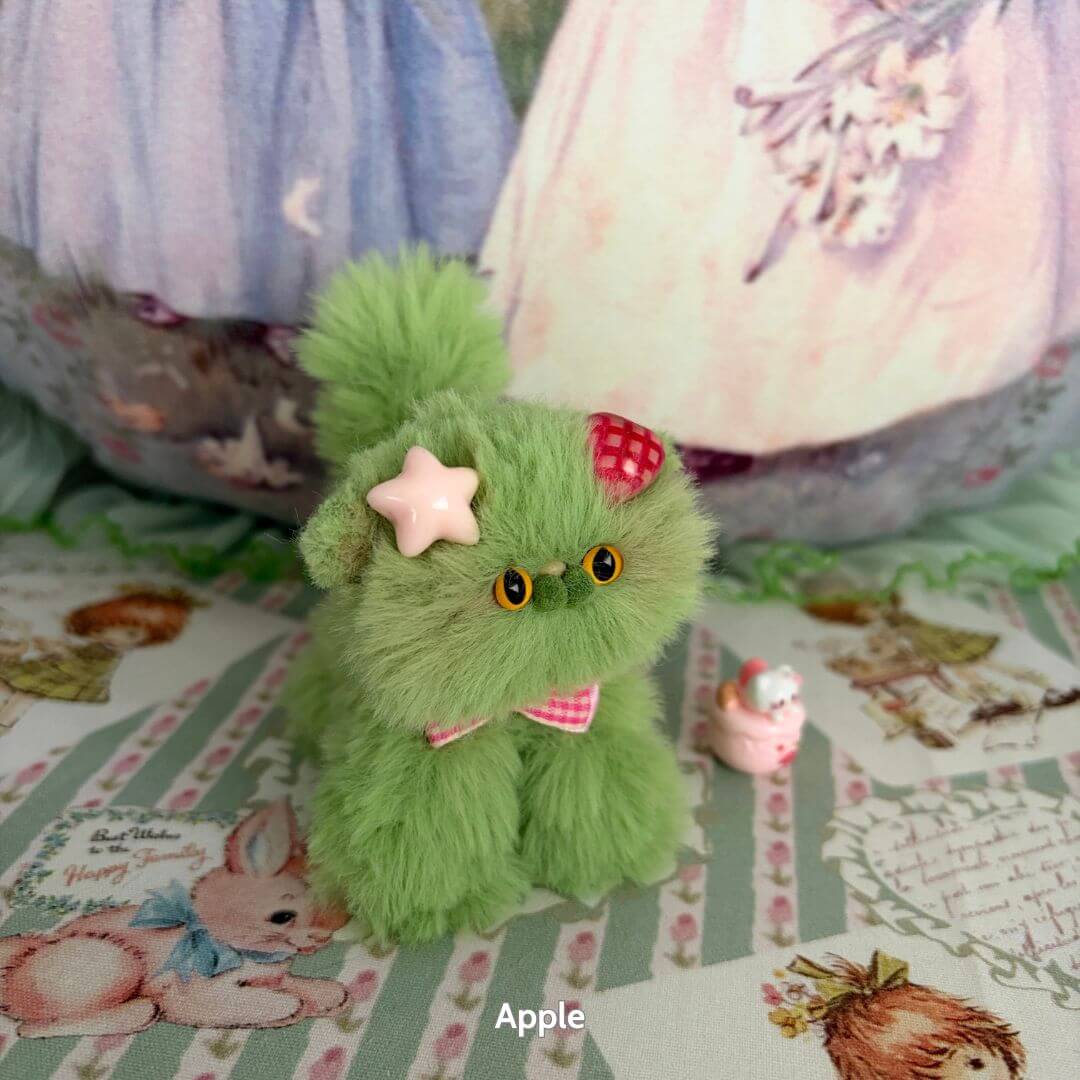 Handmade kitten from the Fruity Kitten Collection, vibrant mint green, wearing a pink bow and fruit-themed decorations.