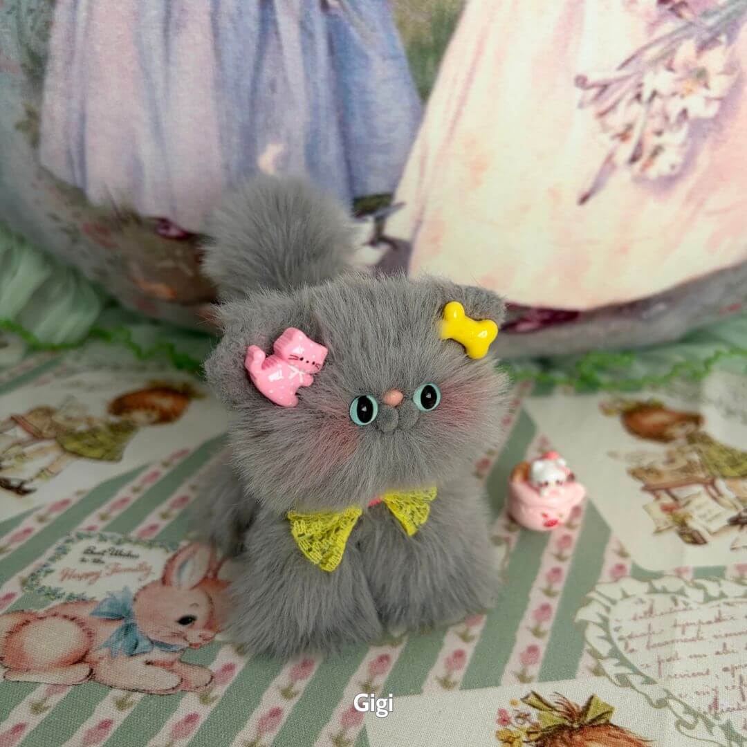 Handmade kitten from the Grey Kitten Collection featuring soft grey fur, yellow bow, and pink accessories, cute kawaii style.