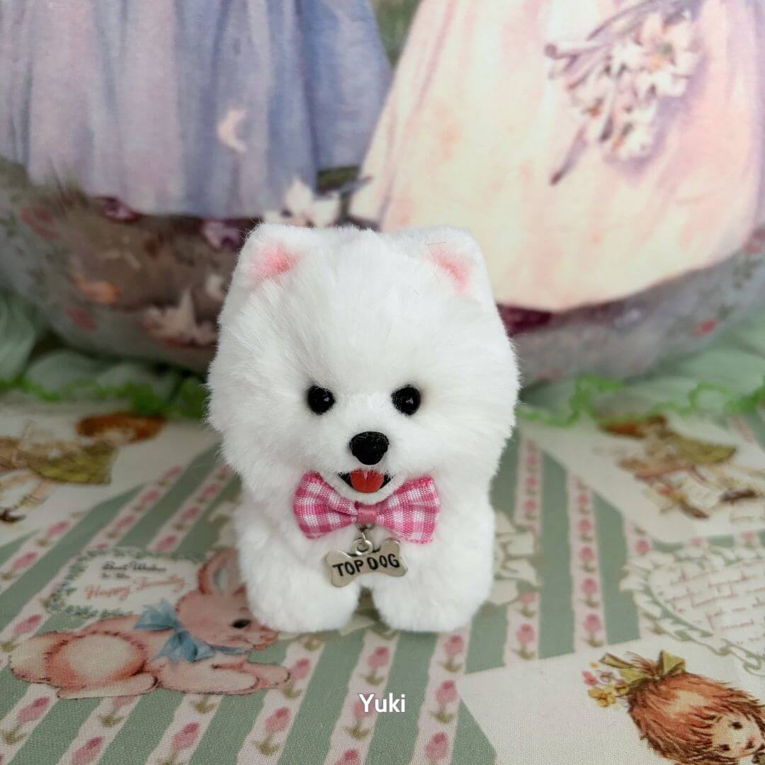 Lifelike Puppy Collection featuring a fluffy white puppy figurine with a pink bow tie, exuding charm and personality.