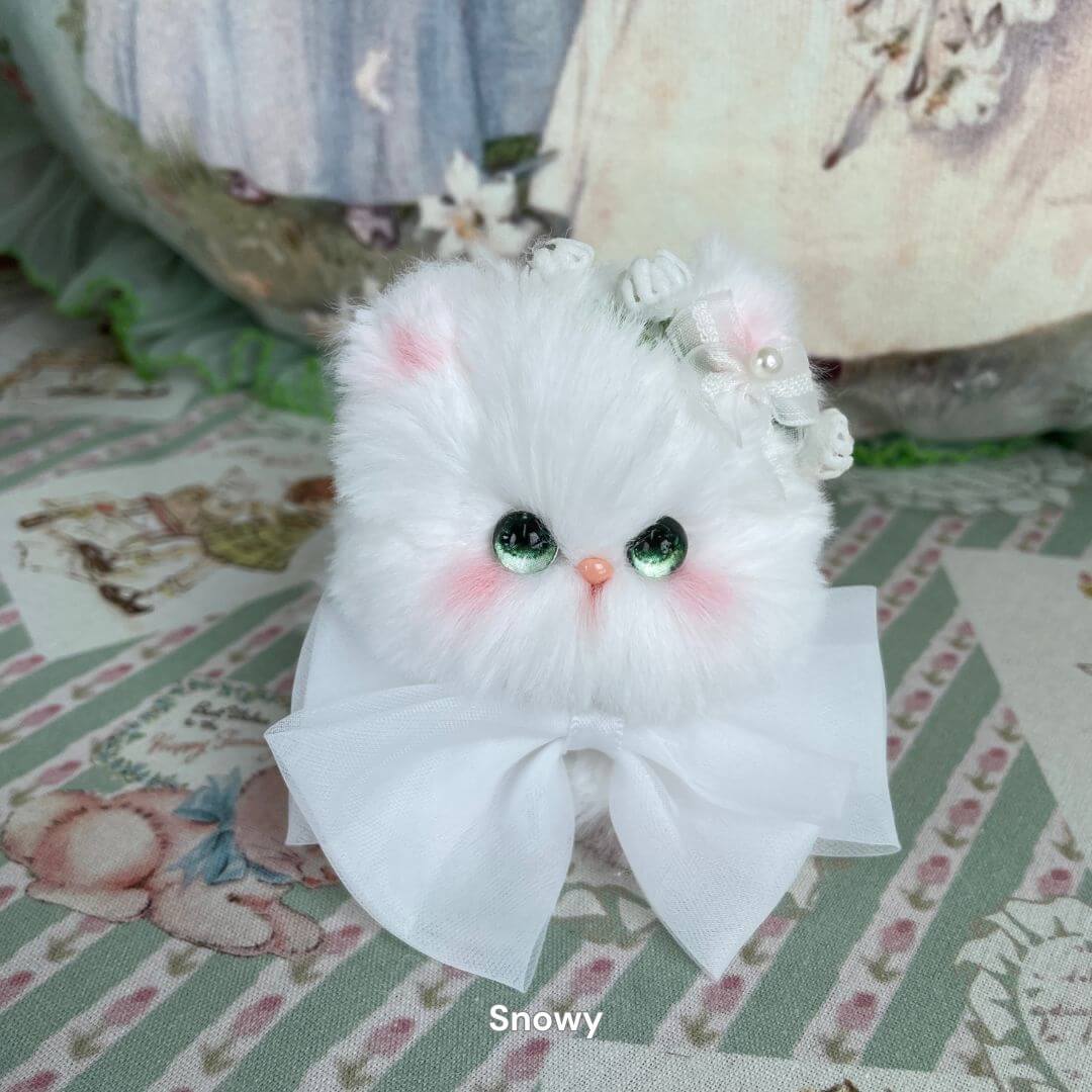 Handmade plush kitten toy with soft white faux fur, green eyes, and white bow, from the Fairy Paws Collection.