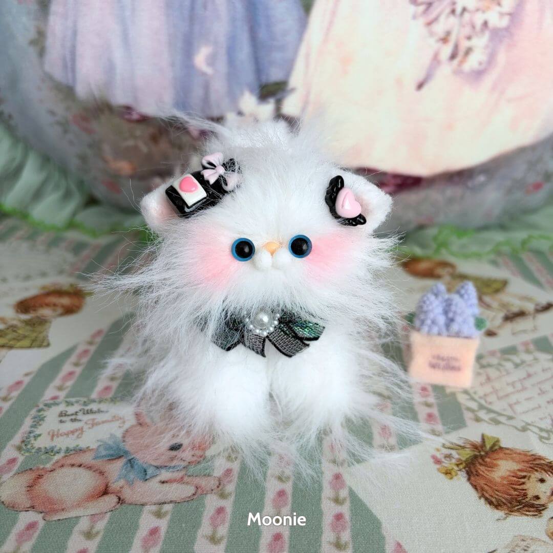 Adorable handmade kitten from the Siberian Snuggles Collection, fluffy white fur, blue eyes, decorated with cute accessories.