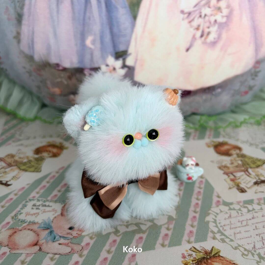 Fluffy Kitten Collection: Cute fluffy kitten figurine in pastel blue with a brown bow, handmade collectible animal decor.
