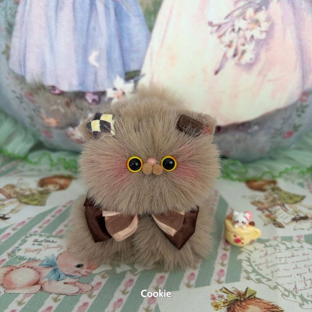 Fluffy Kitten Collection: adorable miniature cat with plush beige fur, whimsical bow, and cute eyes, perfect for collectors.