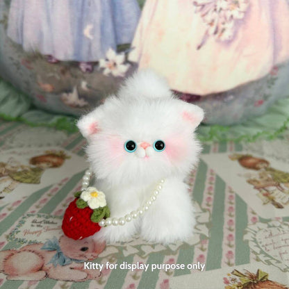Snuggle Bits: Fluffy white miniature kitten with blue eyes wearing a pearl necklace and holding a strawberry purse, cute collectible.